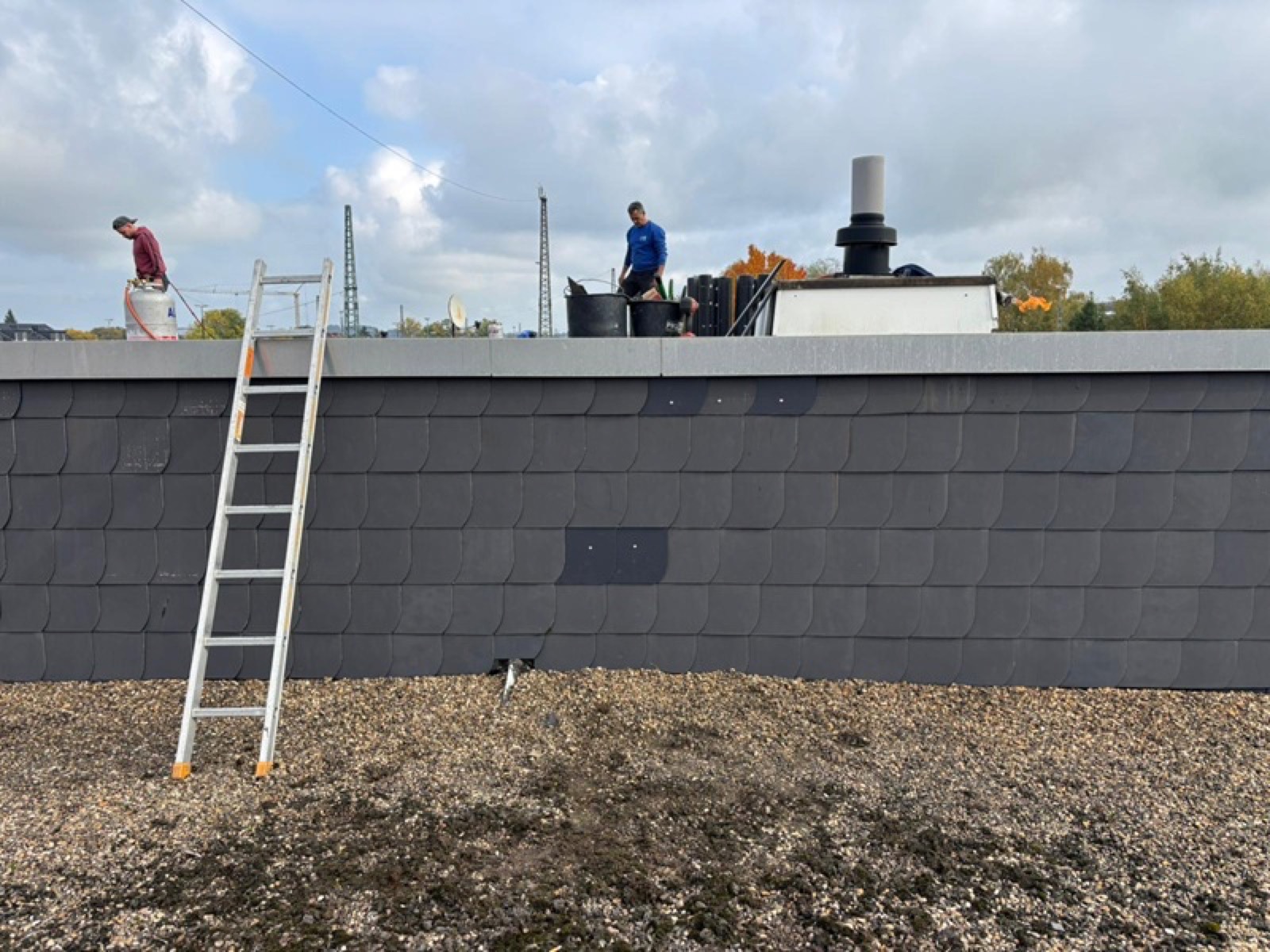 Fassade mit Asbestzement-Schindeln vor dem Rückbau